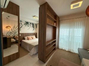 ein Schlafzimmer mit einem Bett und einem großen Spiegel in der Unterkunft Flat na Av JK in Sao Jose do Rio Preto