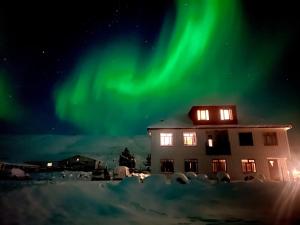 uma casa com a aurora no céu em Guesthouse Storu-Laugar em Laugar