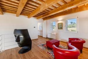 a living room with a black mask and a red chair at Villa Il Morino in Centofinestre