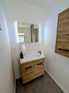 a bathroom with a sink and a mirror at La maison du petit large in La Bernerie-en-Retz