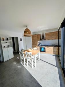 a kitchen and dining room with a table and chairs at La maison du petit large in La Bernerie-en-Retz +4 photos