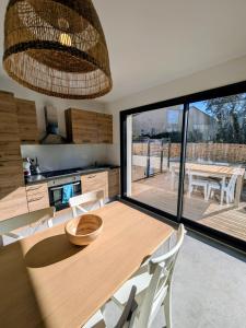 a kitchen with a wooden table and a large window at La maison du petit large in La Bernerie-en-Retz
