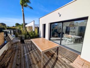 a wooden deck with a table on a house at La maison du petit large in La Bernerie-en-Retz