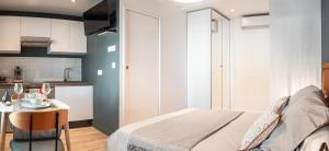 una camera da letto con un letto, un tavolo e una cucina di Le studio Belledonne de Paradis a Chambéry