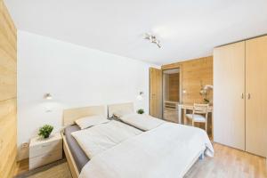 萨斯格伦德Family-friendly apartment with mountain views的一间带床和桌子的白色卧室