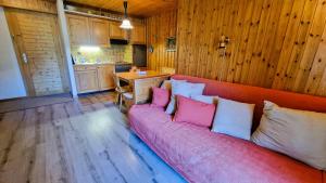 Residence Evolene 31 Appartement 2 personnes في إيفولين: غرفة معيشة بها أريكة عليها وسائد