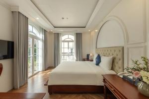 富国Emirates Hotel Phu Quoc的一间卧室，配有一张大床和一扇大窗户。 更多58张照片