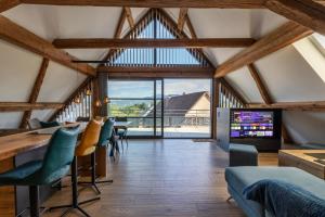 a living room with a vaulted ceiling with wooden beams at Lorenz Home - Gîte d exception & balnéo in Neuve-Église