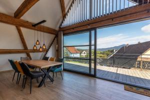 a dining room with a table and chairs and a large window at Lorenz Home - Gîte d exception & balnéo in Neuve-Église