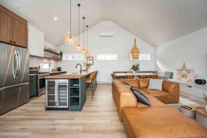 a living room with a couch and a kitchen at Phil Good 1219: Luxurious River View in Charlevoix in Petite-Rivière-Saint-François