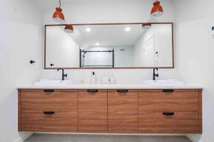 a bathroom with two sinks and a large mirror at Phil Good 1219: Luxurious River View in Charlevoix in Petite-Rivière-Saint-François