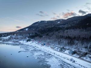an aerial view of a river with snow and mountains at Phil Good 1219: Luxurious River View in Charlevoix in Petite-Rivière-Saint-François