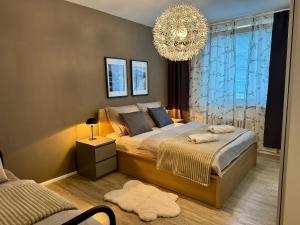 a bedroom with a large bed and a chandelier at Family Apartment 104 in Špindlerův Mlýn