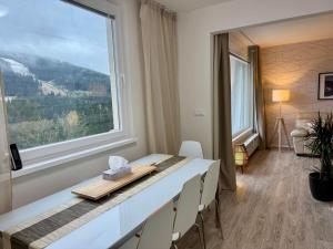 a dining room with a table and a large window at Family Apartment 104 in Špindlerův Mlýn