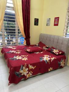 a bed with a red blanket and pillows on it at Wan Z Homestay Pasir Mas in Pasir Mas