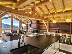 een keuken en een woonkamer in een blokhut bij Les Alpages du Soleil in La Rosière