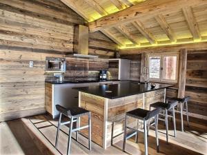 een keuken met een aanrecht en krukken in een hut bij Les Alpages du Soleil in La Rosière