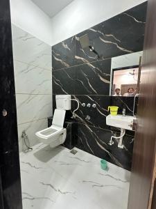 a bathroom with a toilet and a sink and a mirror at Hotel Krishna Raj in Ujjain