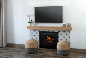 a living room with a fireplace with two stools at Cardiff By The Sea Lodge in Encinitas