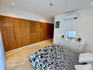 达布阿扎Peninsula Dar Bouazza Superbe appartement en résidence avec piscine activités的一间卧室配有一张床和木制橱柜 更多53张照片