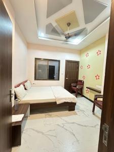 a bedroom with a bed and a ceiling at Hotel Krishna Raj in Ujjain