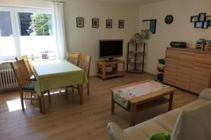 a living room with a table and a television at Haus Kathan in Bechtersweiler