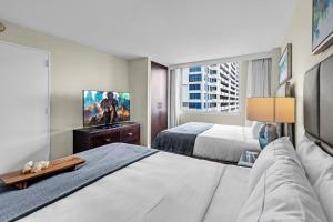 ein Hotelzimmer mit zwei Betten und einem Flachbildfernseher in der Unterkunft Gallery One Resort Access Fort Lauderdale Beach in Fort Lauderdale + 25 Fotos