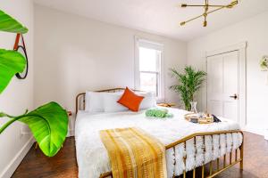 a bedroom with a large bed with orange pillows at Jungle House Chillicothe - Luxury Downtown Homes Free Parking in Chillicothe