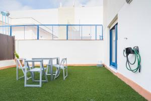 ボルムホスにあるLuxSevilla Bormujos Piscina Free Parkingのパティオ(テーブル、椅子、芝生付)