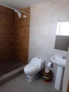 a bathroom with a toilet and a sink at Casa en Atuntaqui in Atuntaqui +22 photos