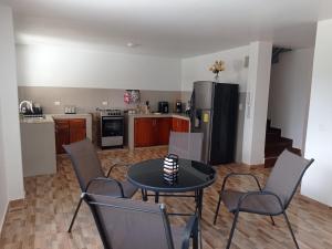a kitchen with a table and chairs and a refrigerator at Casa en Atuntaqui in Atuntaqui