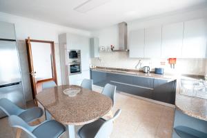 Una cocina con una mesa y sillas en una cocina. en Villa Mirage - by Madeira To Stay, en Arco da Calheta