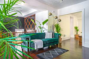 a green couch in a living room with plants at Short North Convention Private Parking Pets! in Columbus