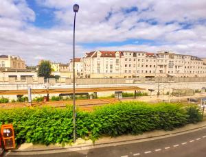 迈松拉菲特Joli duplex refait à neuf, face gare, près Ermitage的大楼前的路灯和长凳