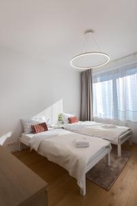 a white room with two beds and a large window at Skau Sky Park Mint by Zaha Hadid 22 Floor 1 Tower Free Parking in Staré Mesto