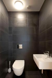 a bathroom with a white toilet and a sink at Skau Sky Park Mint by Zaha Hadid 22 Floor 1 Tower Free Parking in Staré Mesto +28 photos