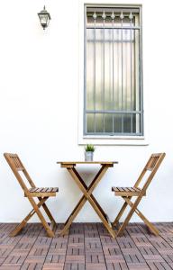 a picnic table and two chairs in front of a window at Romano Rooms in Catania