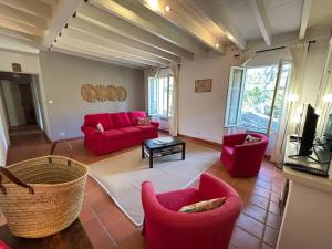 a living room with red chairs and a red couch at Domaine de Cassan in Lafare