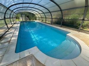 an indoor swimming pool in a greenhouse at Domaine de Cassan in Lafare