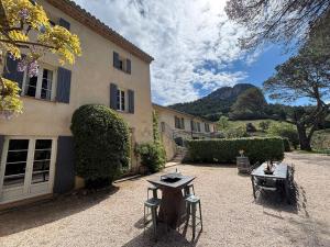 a courtyard with two tables in front of a building at Domaine de Cassan in Lafare