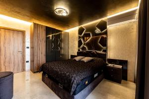 a bedroom with a bed in a room with a wall at Beni Deluxe in Plovdiv