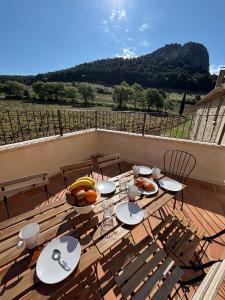 a table with plates of food and fruit on a deck at Domaine de Cassan in Lafare