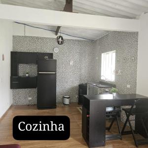 a room with a black refrigerator and a table at Aconchego Brasileirinho Para-ti in Paraty