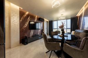 a living room with a table and chairs and a television at Beni Deluxe in Plovdiv