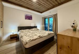 a bedroom with a bed and a large window at Apartmán Resident Harrachov and Wellness in Harrachov +28 photos