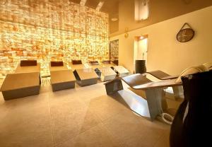 a large room with chairs and a stone wall at Apartmán Resident Harrachov and Wellness in Harrachov