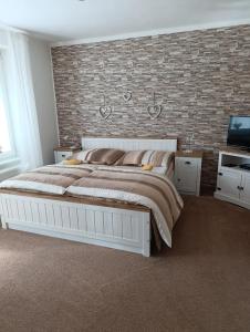 Apartment Krnov في كرنوف: غرفة نوم بها سرير كبير وجدار من الطوب