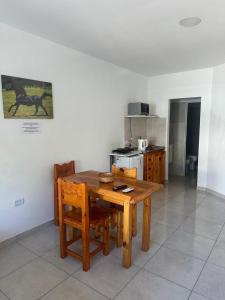 een keuken met een houten tafel en houten stoelen bij departamentos apart quetzal in Villa Carlos Paz