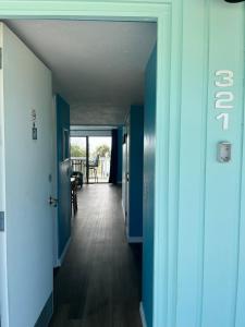 a hallway of a house with blue walls and wooden floors at Sky Blue 321 in Cedar Key +1 photo