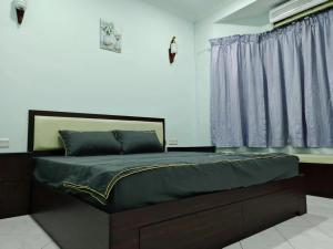 une chambre avec un grand lit avec des rideaux bleus dans l'établissement Be Stay Ipoh with parking - 14pax, 5Rooms, à Ipoh